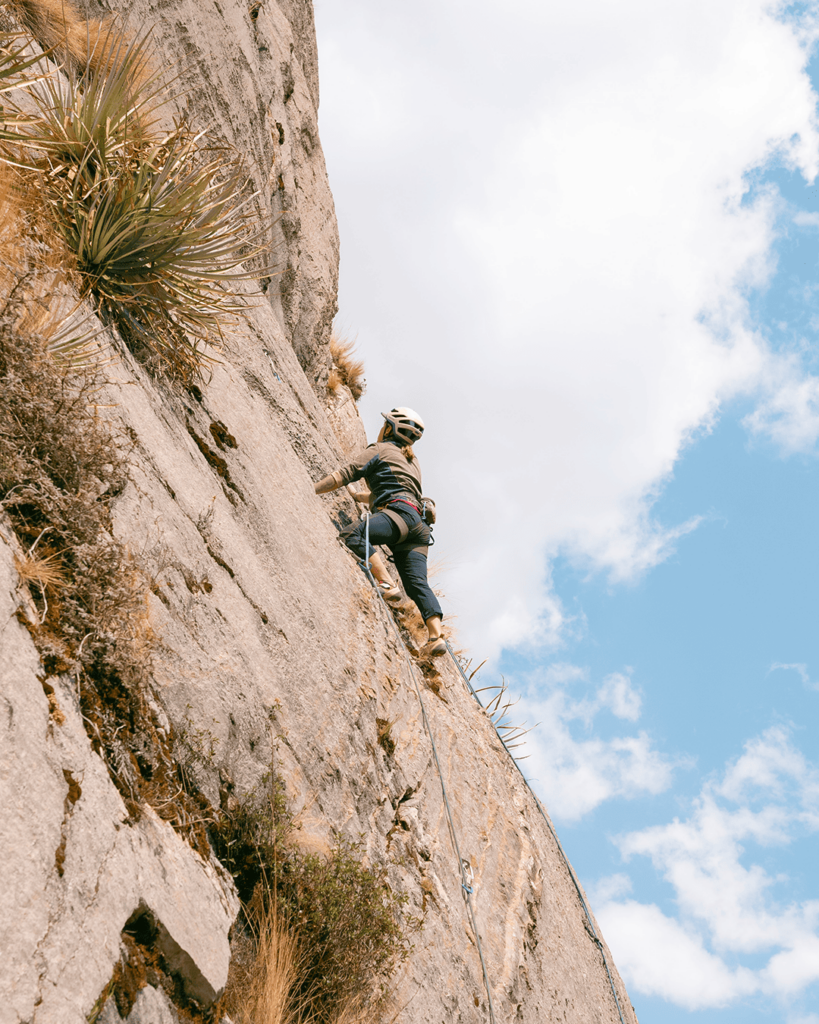 stunning landscape with climber girl pushing on limestone during rock climbing tour with Alejandro Cornejo and Climbing Rooftop in Pitumarca Cusco Peru