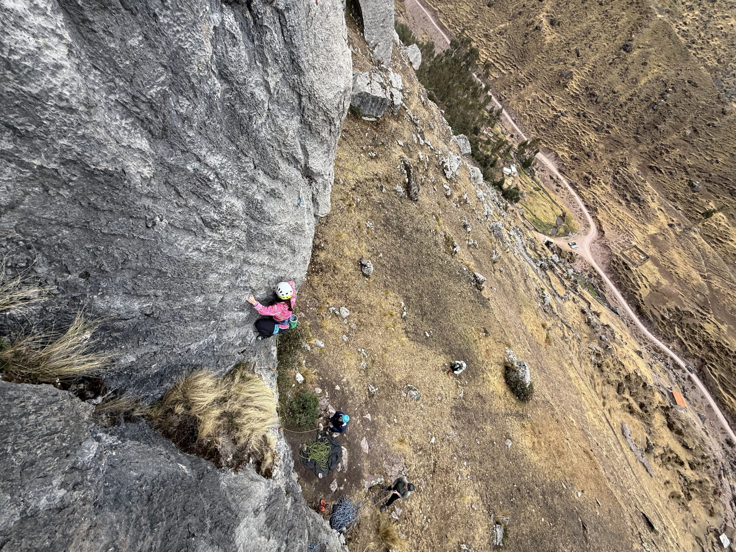 climber girl clipping quickdraws during rock climbing tour with Alejandro Cornejo and Climbing Rooftop in Pitumarca Cusco Peru